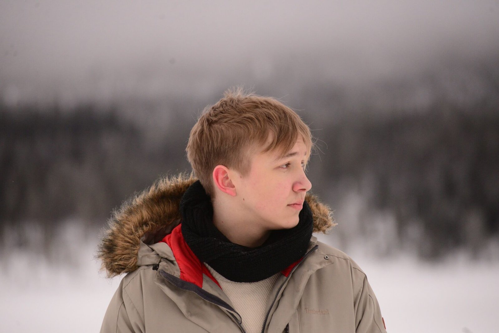 Svensk pojke som tittar åt sidan i snön med hoodiejacka – exempel på plagg från hoodie-tillverkare i Indien, klädtillverkare i Indien, t-shirt-tillverkare i Indien, damkläder tillverkare i Indien, barnkläder tillverkare i Indien, sweatshirt-tillverkare i Indien, herrkläder tillverkare i Indien, plus size kläder tillverkare i Indien, streetwear-tillverkare i Indien.